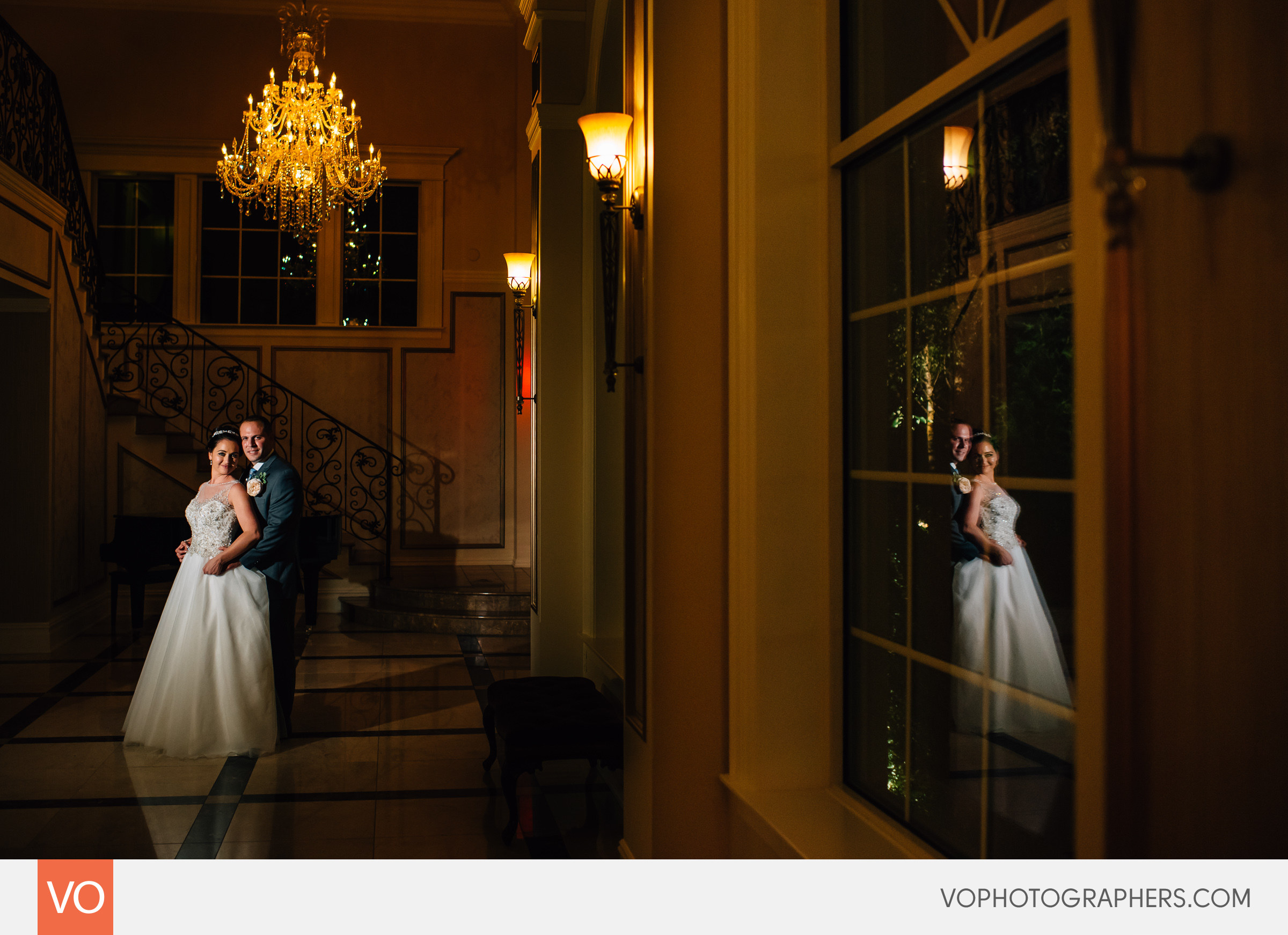 Bride and groom reflection in window, chandelier.