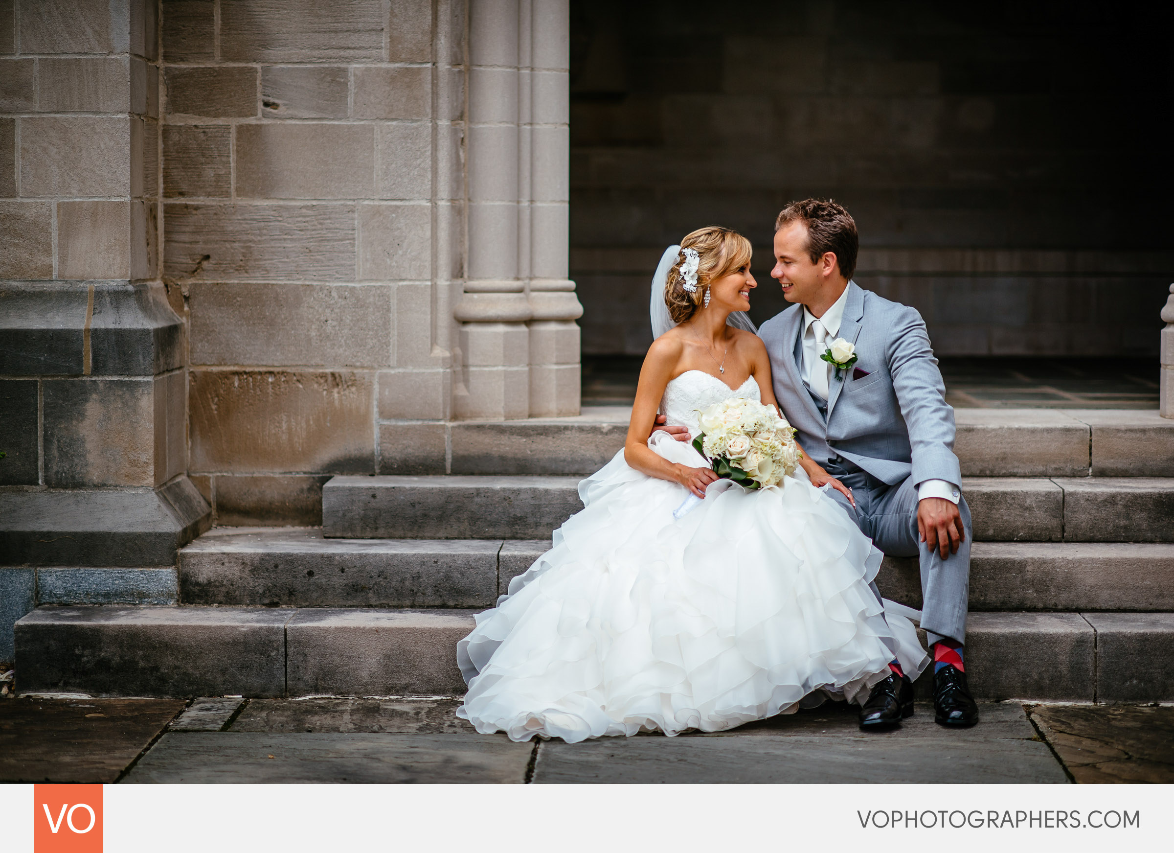 Bride and groom sitting on the steps of Trinity College
